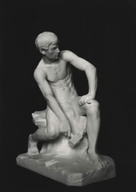 stone sculpture of seated boy